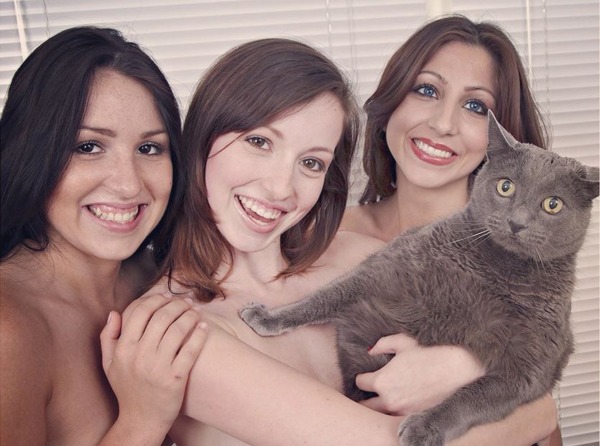 naked girls posing with a cat covering their breasts 